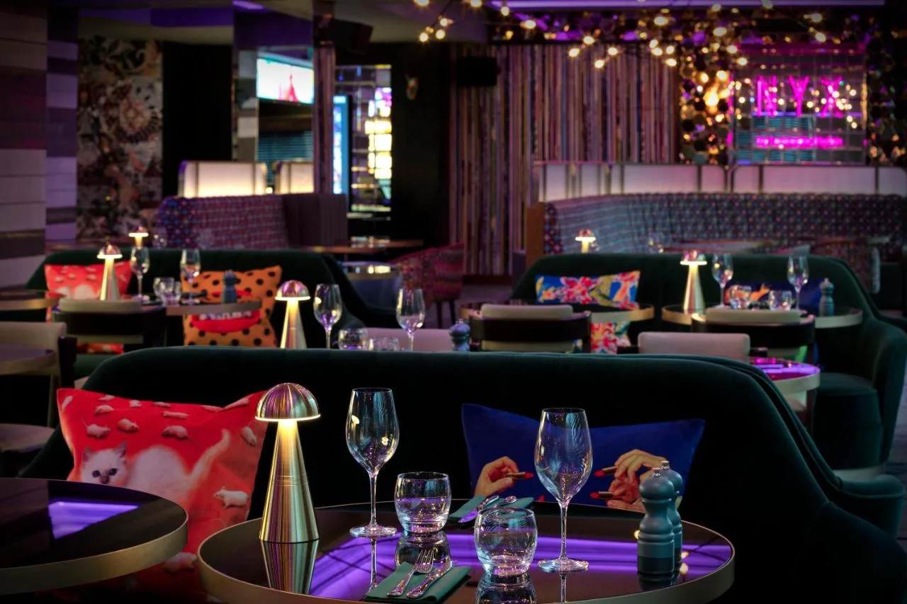 a restaurant with wine glasses on a table at NYX Hotel London Holborn by Leonardo Hotels in London